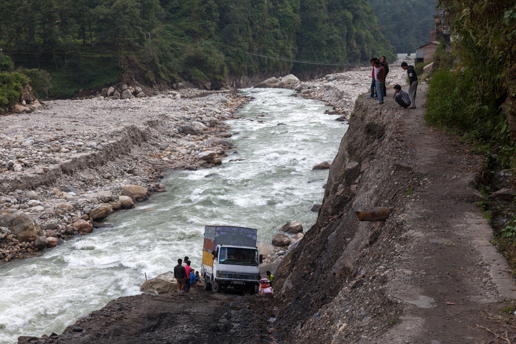 A truck struggling on a steep ascent in Tatopani, just north of Kathmandu, Nepal. This place is a ghost town today, after a quake and flood left it ravaged. The roads, or what is left of them, are incredibly steep. The truck kept rolling back towards the river as it tried to climb up. A harrowing experience for the driver, no doubt.